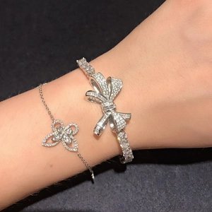 Bracelet jonc à nœud en zircon argenté et gourmette fleur élégante portés au poignet