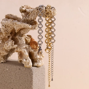 Detail of 14K gold and silver chunky round link chain bracelets on stone props