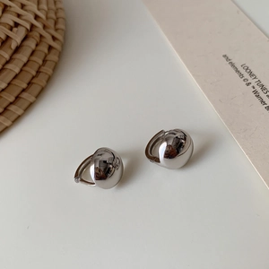 Minimalist silver spherical hoop earrings with a polished metallic finish on a simple background