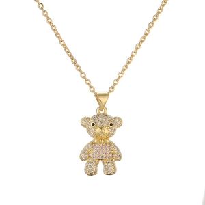 Macro shot of gold-plated teddy bear pendant with pink zircons and crystal details