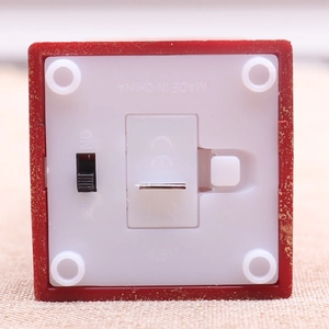 Detail view of the battery compartment and ON/OFF switch on the red decorative lamp base