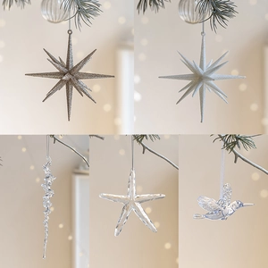 Stelle glitterate e ghiaccioli in acrilico su un albero di Natale con luci bokeh