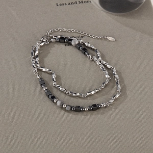 Detail of titanium steel necklace with black cube beads and marble texture stones