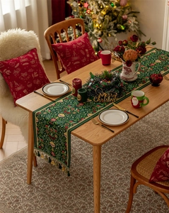 Close-up of green Christmas table runner with red berries and festive tassel details