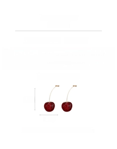 Macro detail showing red resin cherry earrings with silver needles and gold stems