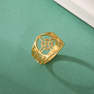 Détail d'une bague en acier inoxydable doré avec des motifs floraux évidés