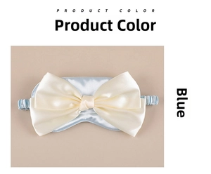 Flat lay of a light blue silk sleep mask with a large decorative cream white bow
