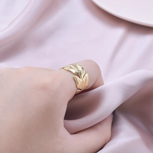 Minimalist gold leaf stainless steel adjustable open ring worn on hand with silk background
