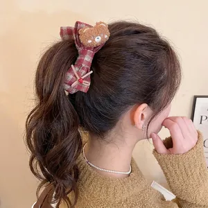Cute plaid bow hair clip with brown plush bear and heart detail on female model ponytail