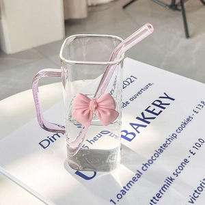 Close-up of square glass cup featuring a pink 3D bow and matching straw detail