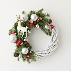 Christmas wreath with white rattan base, green pine needles, silver baubles, and white reindeer