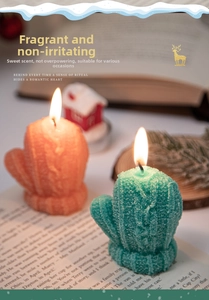 Detail of glove-shaped candles with knitted texture on an open book in a festive scene
