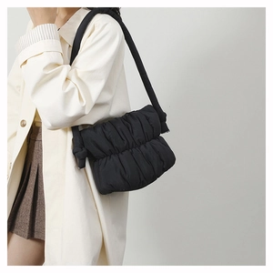 Fashionable black padded cloud bag with soft pleated nylon texture shown as an underarm bag