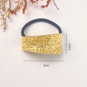 Detailed view of golden irregular textured metal hair tie showing 5x2.5cm size dimension