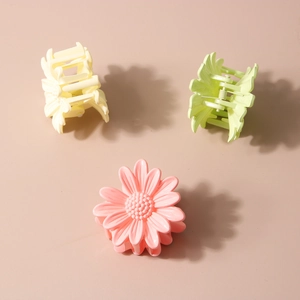 Three colorful daisy hair claw clips in yellow, green, and pink for a sweet style