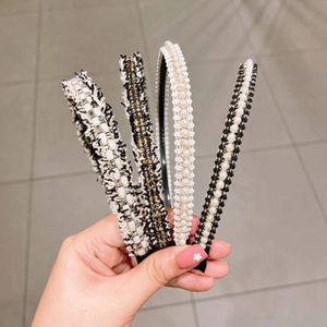 Close-up of four black and white woven headbands with elegant pearl and bead accents