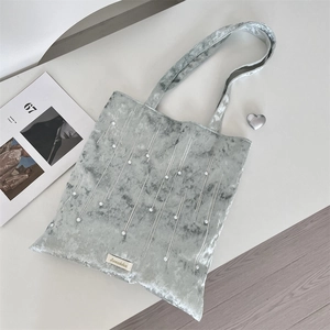 Detail of grey velvet tote bag featuring white pearl accents and branded Sorakka tag