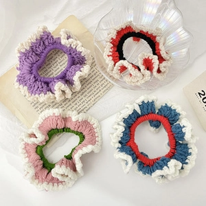 Flat lay of handmade colorful crochet scrunchies with wavy pleated edges and thick texture