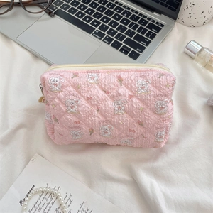 Detailansicht einer rosa gesteppten Kosmetiktasche mit süßem Hasen- und Blumenmuster