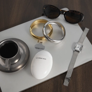 Polished gold and silver chunky stainless steel bangles set against a stylish desk