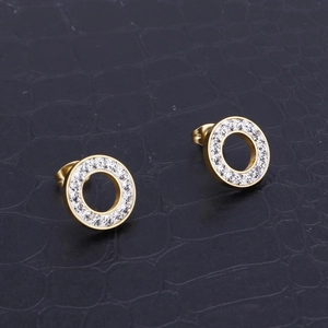 Golden round crystal earrings with pave-set stones on a black crocodile texture background