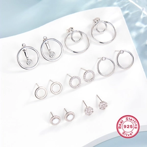 Close-up of S925 sterling silver earrings set with zircon on white stone base