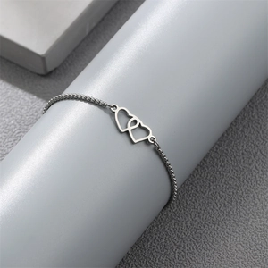 Detailed view of silver interlocking heart charms on a box chain bracelet