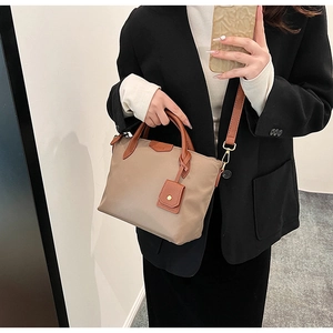Mirror selfie showing the khaki nylon tote bag with brown leather handles and strap