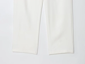 Detail of the stitching and straight-cut hem on white tailored trousers for women