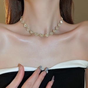 Gros plan d'un collier en zircone étincelante porté par un mannequin sur chaîne dorée