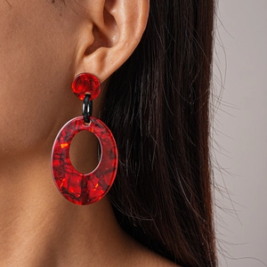 Retro acrylic hollow oval drop earrings with red and black marbled texture on a model