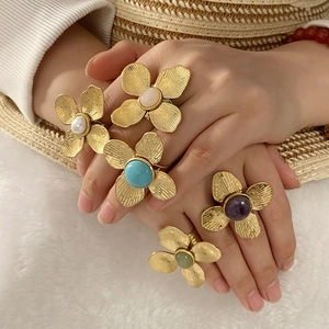 Bagues fleurs style palais français avec pierres naturelles présentées sur les mains