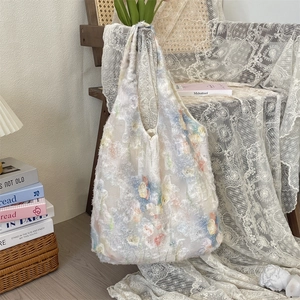 Detailed close-up of 3D floral lace and mesh fabric on a French style tote bag