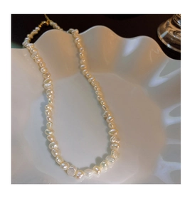 Close-up of baroque irregular freshwater pearl necklace on white decorative plate