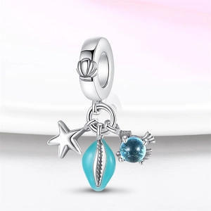 Macro view of silver ocean-themed charms with starfish, shell and blue fish on white background