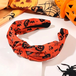 Macro detail of the knotted orange headband with black Halloween pumpkin and bat prints