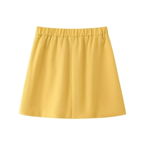Détail d'une mini-jupe jaune avec taille élastique et texture de tissu lisse