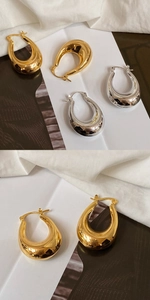 Detailed view of chunky teardrop U-shaped earrings in polished gold and silver finishes