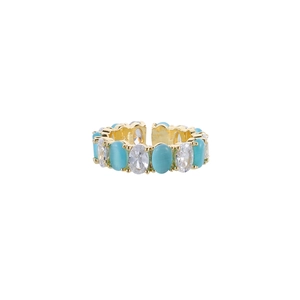 Detail of adjustable gold ring featuring alternating green stones and sparkling zircons