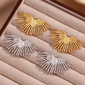 Close-up of gold and silver fan-shaped sunburst earrings on beige velvet jewelry box