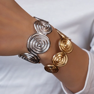 Detailed view of wide spiral geometric open bracelets in polished gold and silver metal