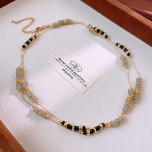 Detail view of double-layered agate bead necklace with gold accents and lobster clasp