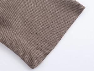 Close-up of brown knit fabric showing soft texture and fine stitching detail