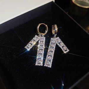 Close-up of sparkling zircon square hollow earrings with silver finish in a black jewelry box