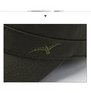 Detail of army green cotton cap featuring precise golden bird embroidery on the side