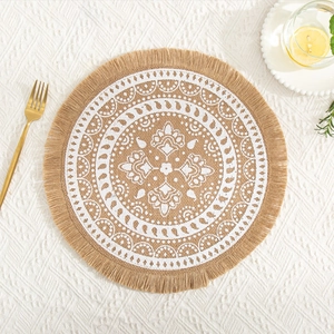 Detail of round jute placemat with white mandala pattern and stylish fringe edges
