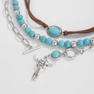 Close-up of Bohemian layered necklace with turquoise beads and silver bull skull pendant