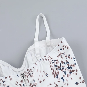 Detail of adjustable straps and silver zipper on white leopard print camisole top