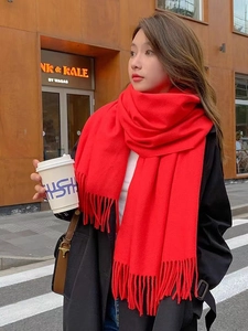 Close-up of vibrant red cashmere-style scarf with long tassels and thick soft texture