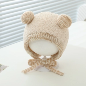 Detail of beige plush baby earflap hat with cute ears and striped chin straps